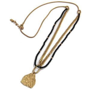Long gold necklace with black glass beads and battered gold pendant